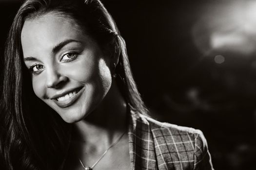 Portrait of a young European girl with long hair in a coffee shop in the evening light, a tall Girl in a jacket with long hair in a cafe.