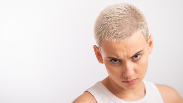 Displeased young caucasian woman with short haircut on white background