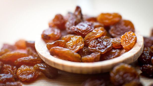 Raisins in a wooden spoon