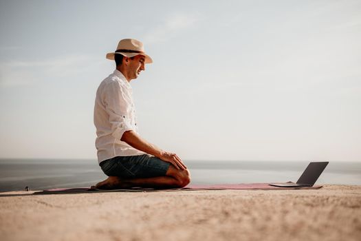 freelancer businessman working remotely on laptop at the beach near the sea