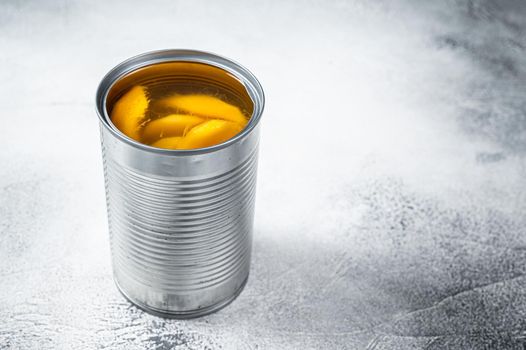 Canned mango slices in syrup in a metal can. White background. Top view. Copy space.
