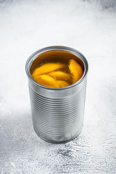 Canned mango slices in syrup in a metal can. White background. Top view.