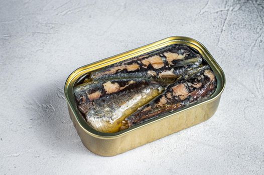 Open can with sardine in olive oil. White background. Top view.