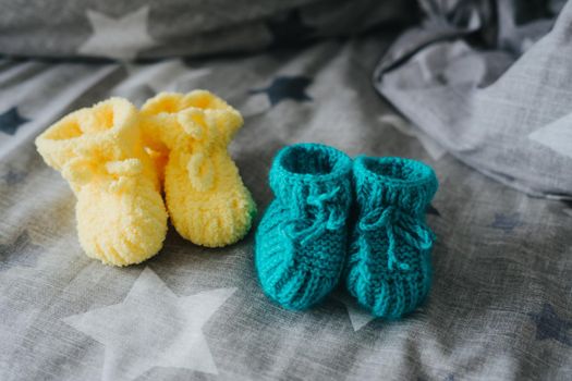 Mint and yellow knitted booties for a child. Knitted socks for the baby.