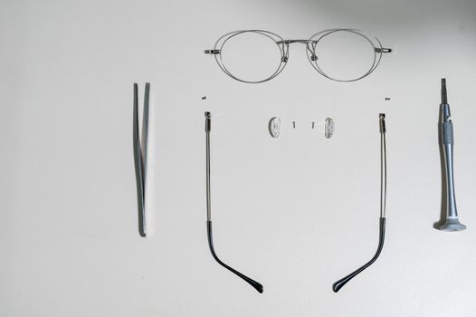 Disassembled glasses frame and tools. Optics work table