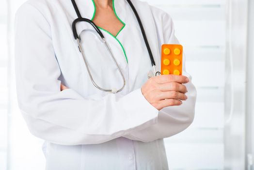 Female doctor with pack of pills