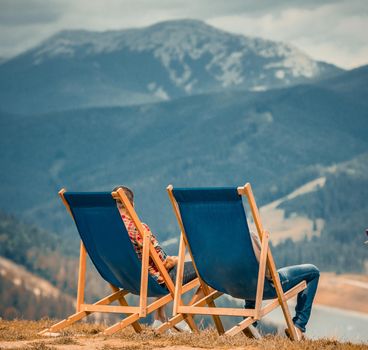 Two blue sunbeds on the top of the mountain