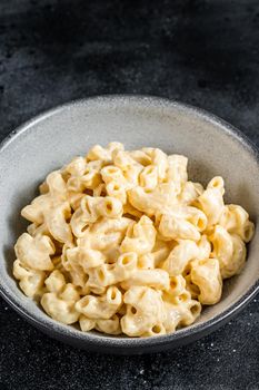 Mac and cheese american macaroni pasta with cheesy Cheddar sauce. Black background. Top view.