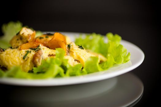 fried omelet with forest mushrooms chanterelles, isolated on black background
