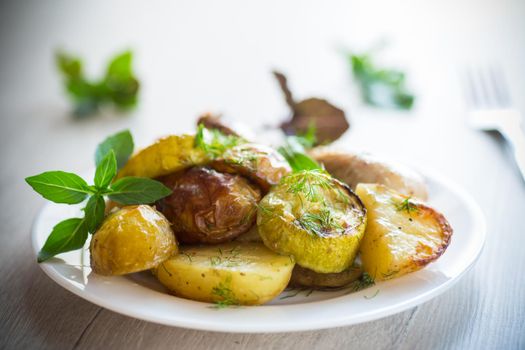 Early baked potatoes with zucchini and chicken, on a wooden table