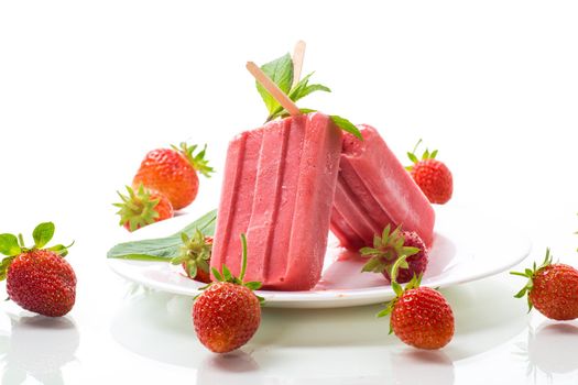 homemade strawberry ice cream on a stick made from fresh strawberries in a plate isolated on white background