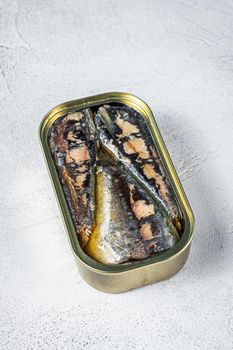 Open can with sardine in olive oil. White background. Top view.