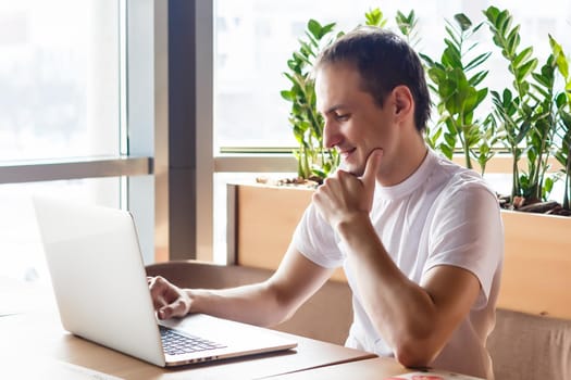 Shot of a young businessman working on his laptop in a cafe shop. Selective focus.