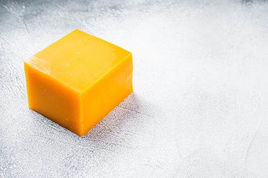 Cheddar Cheese block on a kitchen table. White background. Top view. Copy space.