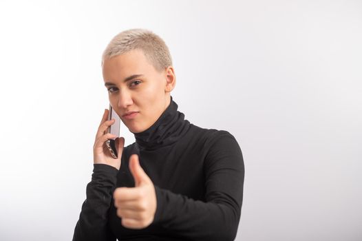 Young caucasian woman with short hair uses a smartphone on a white background