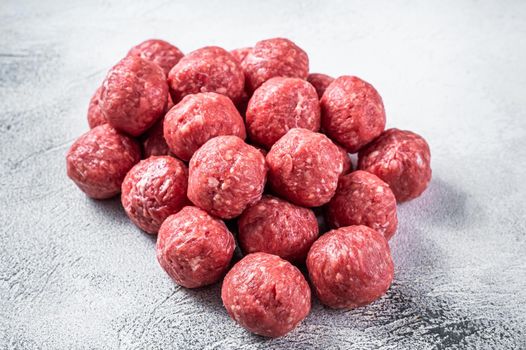 Uncooked Raw beef and pork meatballs with spices on kitchen table. White background. Top view.