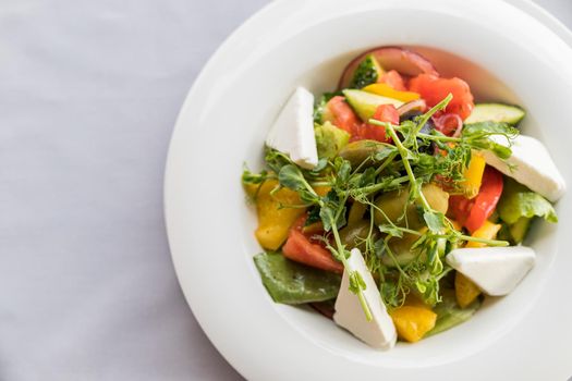 Greek salad with fresh vegetables, feta cheese and black olives