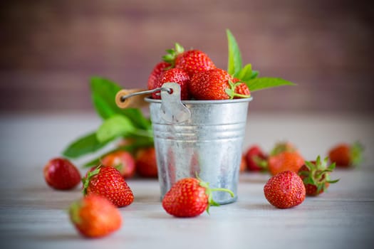 harvest of red ripe natural strawberries on a wooden table