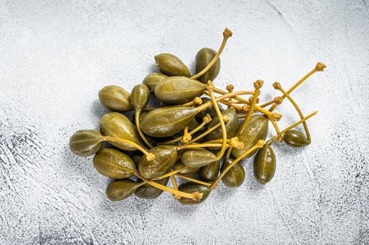 Pickled capers on a kitchen table. White background. Top view.