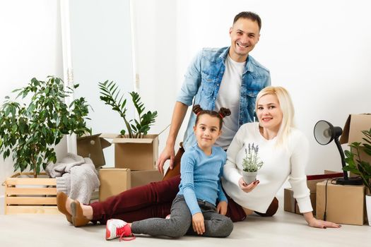 Family unpacking cardboard boxes at new home