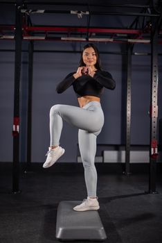Asian woman doing platform exercises in the gym.