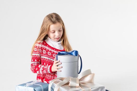 Joyous female kid shouting holding gift-wrapped box being excited and surprised to get birthday present, over pink background