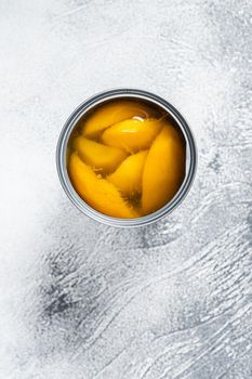 Canned mango slices in syrup in a metal can. White background. Top view.