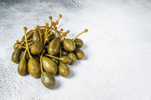 Pickled capers on a kitchen table. White background. Top view. Copy space.