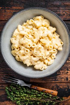 American dish Mac and cheese macaroni pasta with Cheddar. Dark wooden background. Top view.