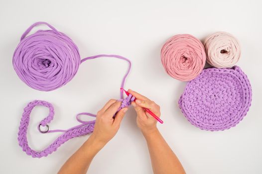 Close-up of a woman crocheting a basket of cotton yarn