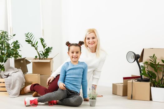 Family unpacking cardboard boxes at new home