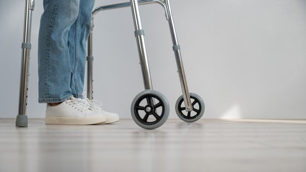 Close-up of female legs with walkers. The girl walks with the help of special equipment