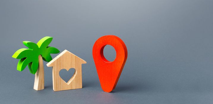 House with a heart and a red navigation pointer pin. Choosing a place for a romantic trip. A tourist guide in the post-pandemic world. New rules for traveling and staying at popular resorts.