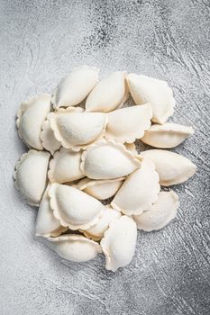 Raw frozen dumplings pierogi on a kitchen table. White background. Top View. Copy space.