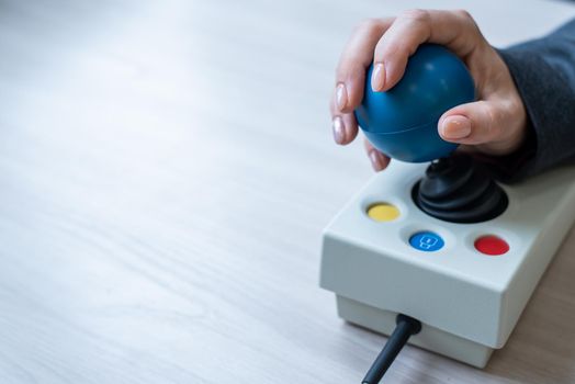 Woman with cerebral palsy works on a specialized computer mouse