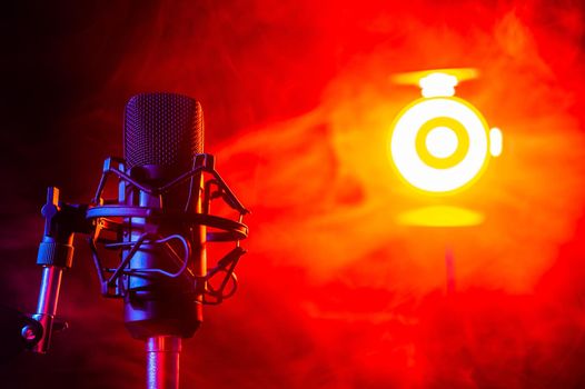 Professional microphone in red smoke on a black background