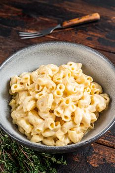 American dish Mac and cheese macaroni pasta with Cheddar. Dark wooden background. Top view.