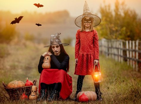 Children dressed for halloween with festive decorations on autumn nature background