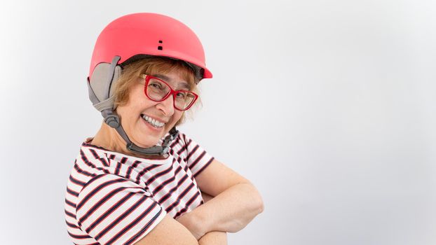 Happy elderly woman in goggles and pink ski helmet on a white background.