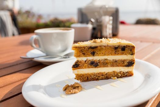 carrots and pumpkin cake with coffee cream in a cut on the plate