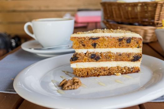 carrots and pumpkin cake with coffee cream in a cut on the plate