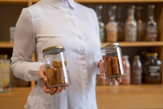 A woman holds a jar with Sweet pureed fruit pastila. Natural weight sweets in an eco store.