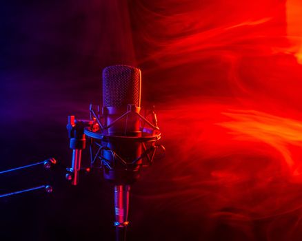 Professional microphone in red smoke on a black background
