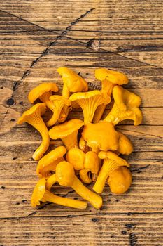 Raw uncooked wild Chanterelles mushrooms. Wooden background. Top view.