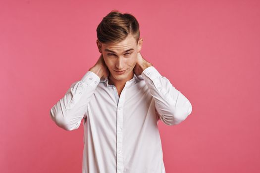 Young man in white shirt posing on pink background. High quality photo