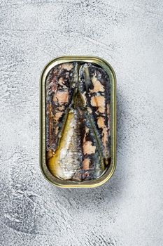 Open can with sardine in olive oil. White background. Top view.