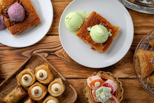 Turkish dessert kunefe served with ice cream on wooden background, close up