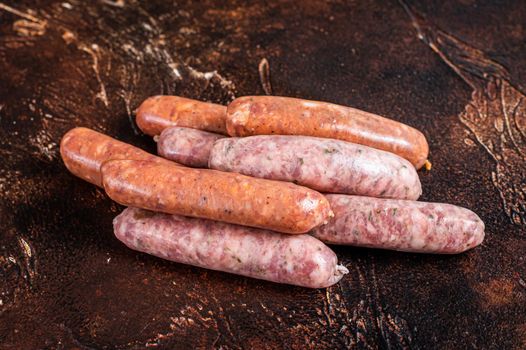 Raw barbecue sausages Chorizo and Bratwurst with spices. Dark background. Top View.