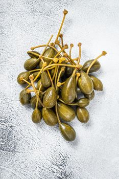 Pickled capers on a kitchen table. White background. Top view.