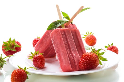 homemade strawberry ice cream on a stick made from fresh strawberries in a plate isolated on white background